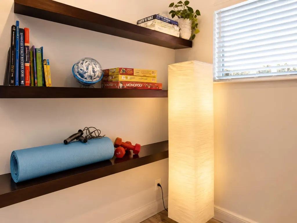 Coin jeux avec livres, jeux de société, tapis de yoga et haltères