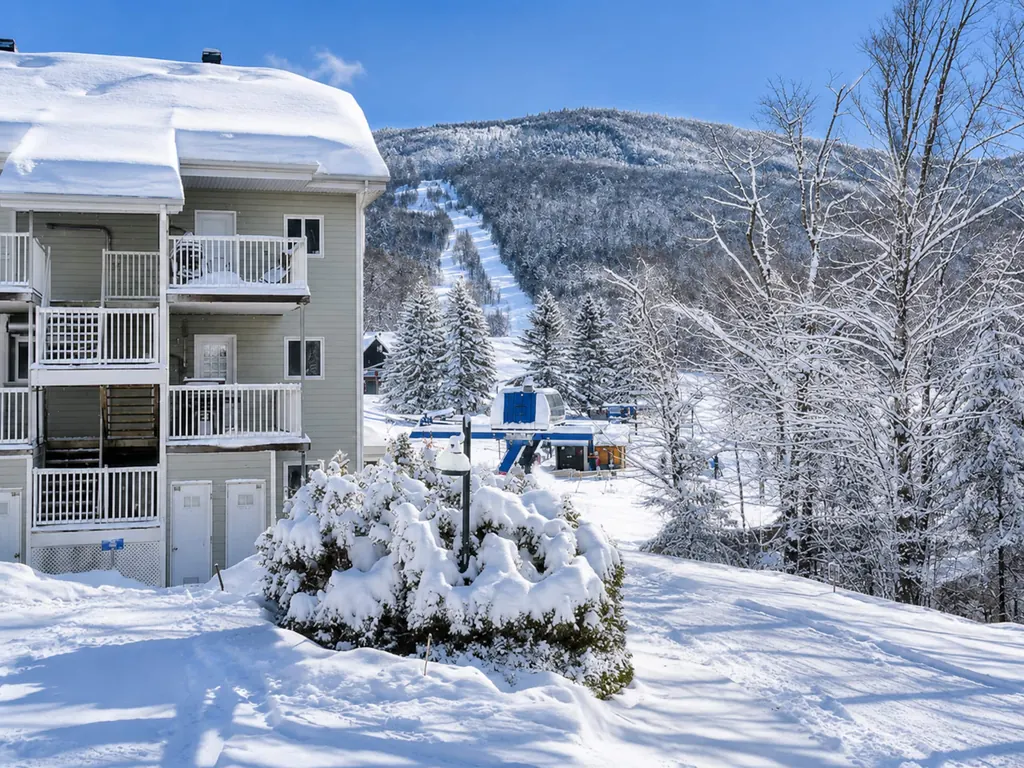 Le condo sous la neige avec la piste de ski juste derrière