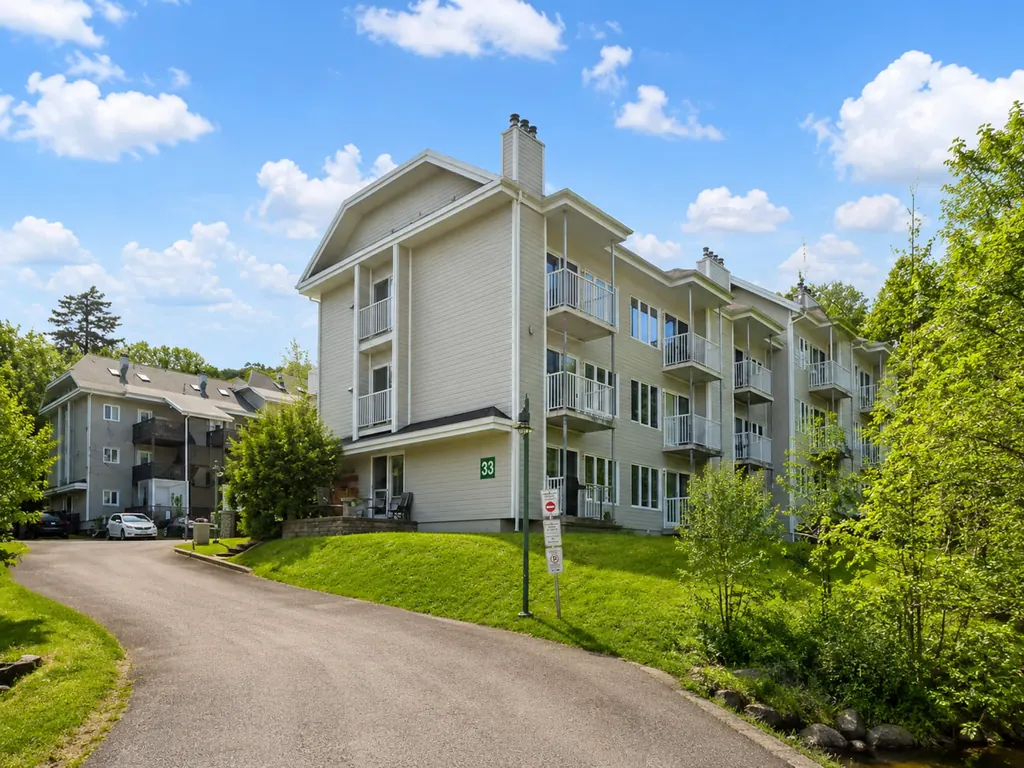 Immeuble du condo entouré de verdure au printemps