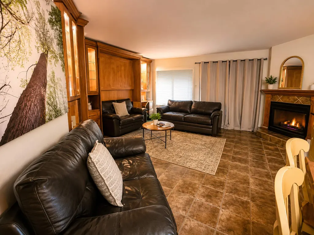 Grand salon avec canapés en cuir, foyer et meuble en bois